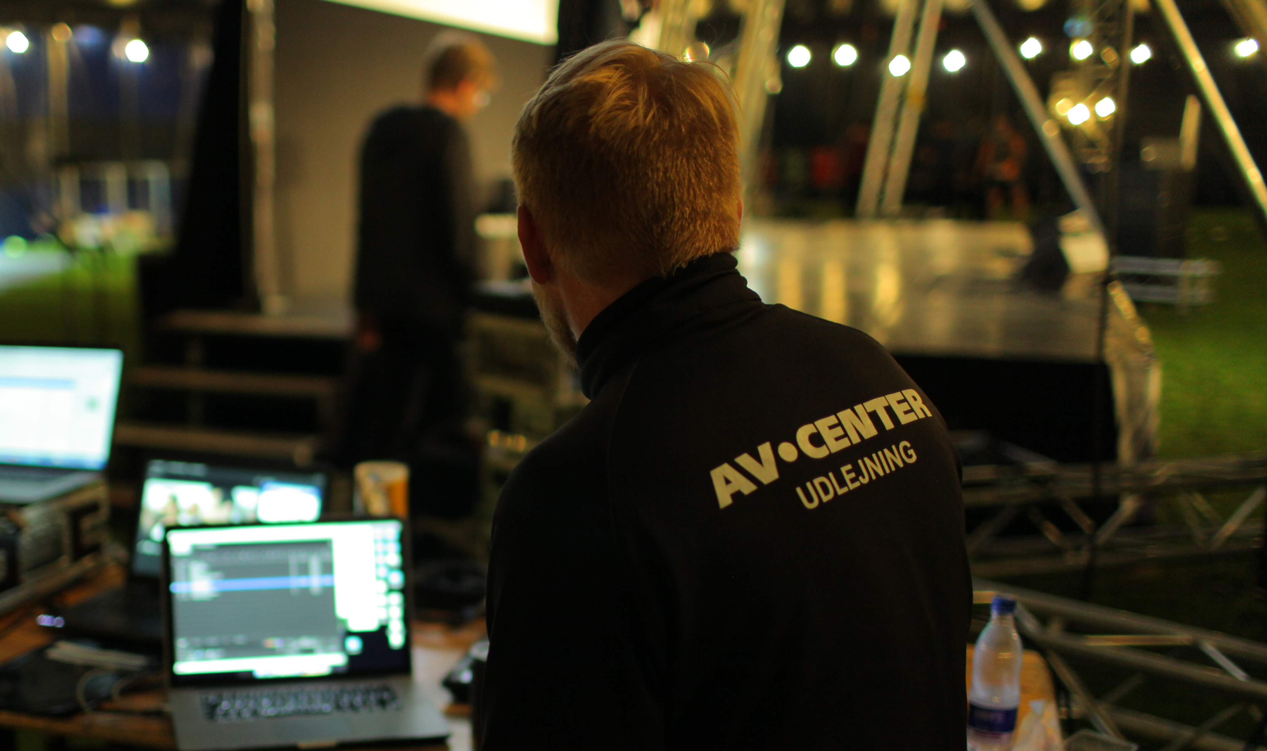 Udlejningstekniker sidder foran computer ved scene