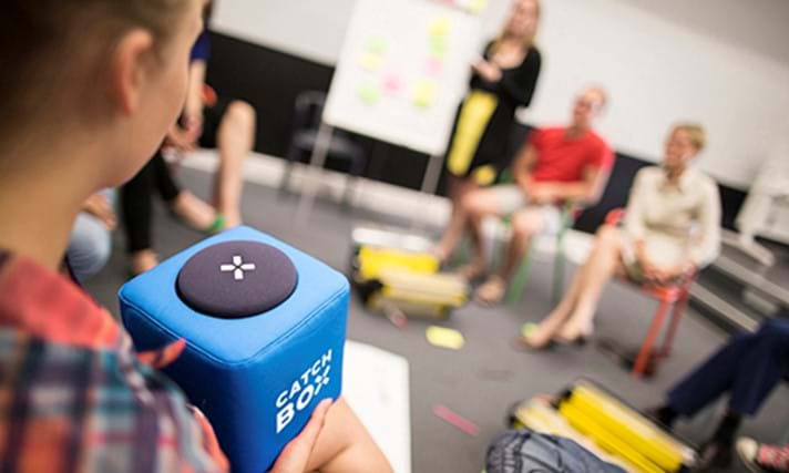 Mødedeltager holder og taler i Catchbox