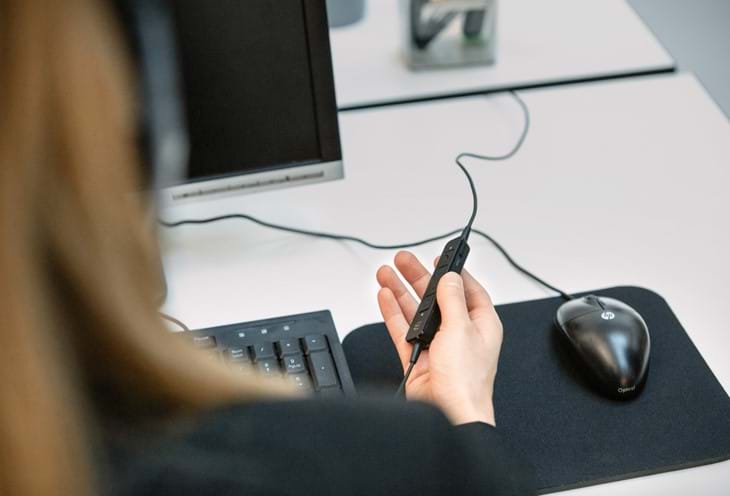 Kvinde I Forgrund Betjener Epos Headset Ved Computer Edit